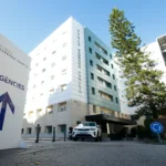 Infographic showing services, specialties, facilities, and location of Clínica Sagrada Família including 24/7 emergency care, surgical departments, and patient facilities in Barcelona.