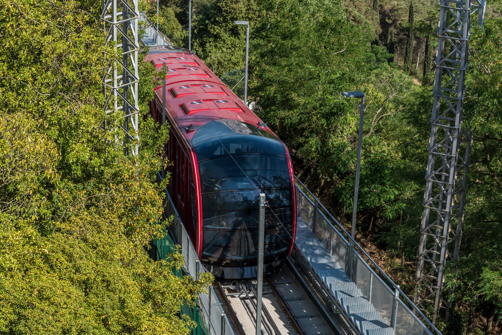 Modern infographic of the Cuca de Llum funicular in Barcelona showing the glass cable car ascending Tibidabo Mountain with skyline views, key travel facts, and route highlights for 2026 visitors.