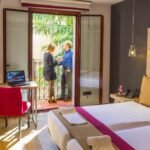 Infographic showing best hotels near Sagrada Familia Barcelona with map, pricing comparison, and top areas including Eixample, Gràcia, and El Clot