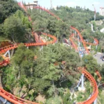 Tibidabo Amusement Park in Barcelona at sunset featuring the Avió airplane ride, Ferris wheel, panoramic skyline views, vintage attractions, and Temple of the Sacred Heart.
