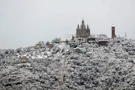 Tibidabo weather infographic showing seasonal temperatures, climate differences with Barcelona, wind and visibility conditions, and best time to visit Tibidabo mountain in 2026.