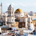 Infographic showing the weather in Spain in March, including temperatures, sunshine, rainfall, warmest regions, best cities to visit, packing tips, and spring travel advice for 2026.